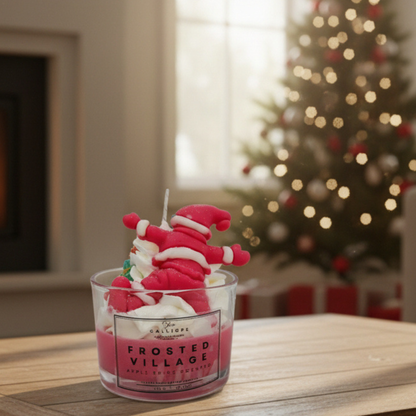 Frosted Village candle in a glass jar with a Christmas tree in the background