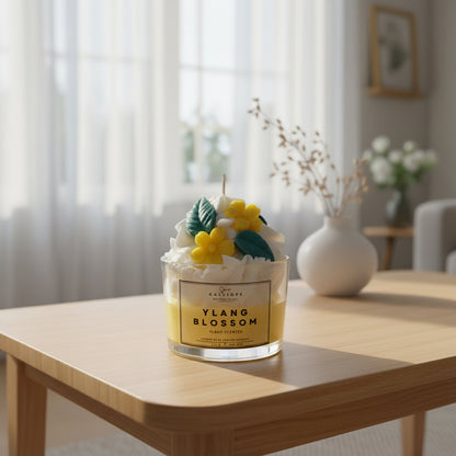 Κερί “Ylang Blossom” πάνω σε ξύλινο τραπέζι με θολό φόντο.